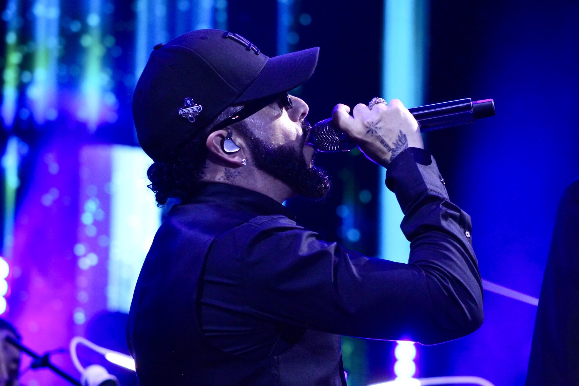 Yandel cantando bajo luz azul